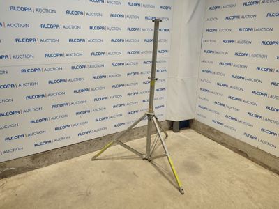 un trépied devant un mur sur lequel est accrochée une pancarte