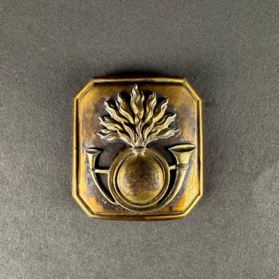 brass clad button with a thistle design on a grey background