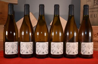 six bottles of wine are lined up in a row on a table