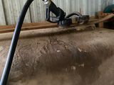 a large tank with a hose attached to it in a building