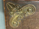 a brown leather case with a decorative design on it