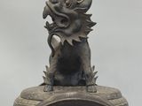 a statue of a dragon sitting on top of a fire hydrant