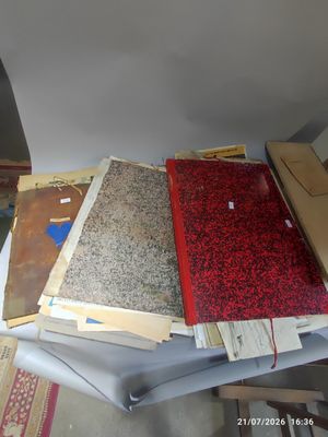 a lot of papers on a table next to a chair