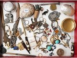 un plateau rouge sur lequel sont disposés de nombreux bijoux