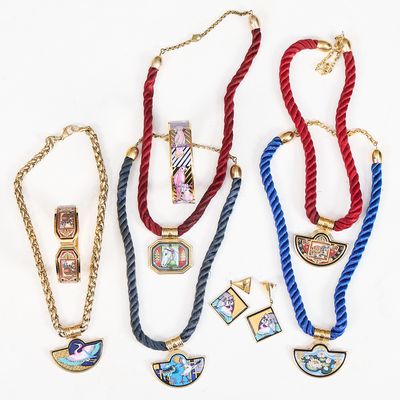 Plusieurs colliers et bracelets sont exposés sur un fond blanc