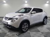 the white nissan juke suv is parked on a checkered floor
