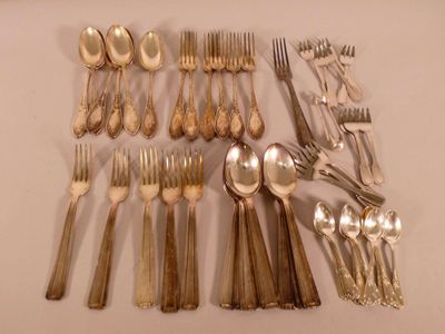 un grand nombre de cuillères et de fourchettes en argent disposées sur une table