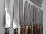 a lot of knives that are lined up on the wall