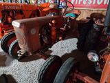 two old tractors that are parked in a garage