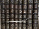 plusieurs vieux livres empilés les uns sur les autres sur une étagère