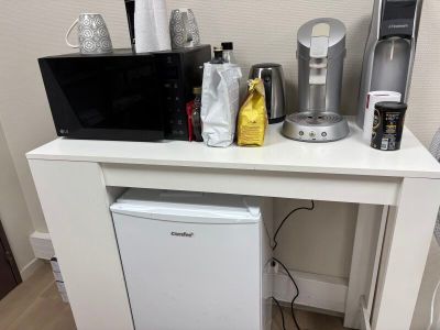une petite table blanche sur laquelle est posé un micro-ondes