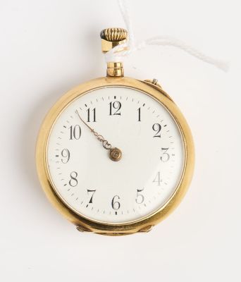 une montre à gousset en or suspendue à un mur blanc