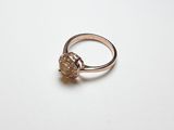 un gros plan d'une bague ornée d'une fleur