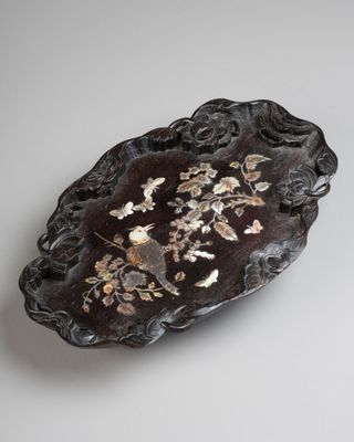 an image of a black and gold plate with flowers on it