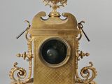 a gold clock that is sitting on a table