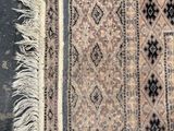 an old rug with fringes on a wooden floor