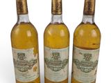 three bottles of wine sitting next to each other on a white surface
