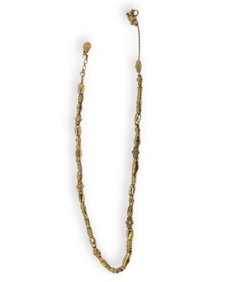 un collier en or composé d'une longue chaîne formée de perles métalliques