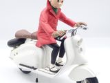 a figurine of a man riding on a scooter