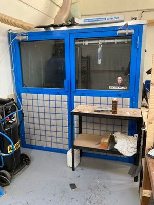 une pièce avec une porte bleue et un établi à l'intérieur
