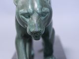a green statue of a bear on a marble block