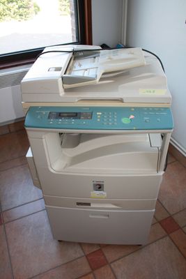 a multi - function printer sitting on top of a tile floor