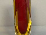 un vase rouge orné d'une bande jaune