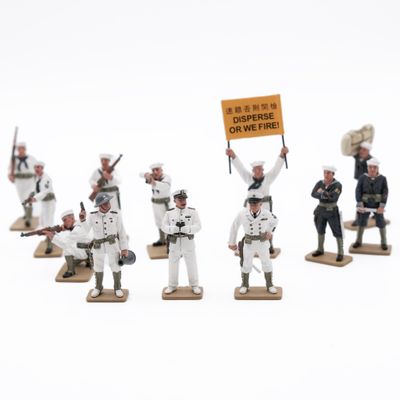 several figurines of men dressed in military uniforms holding a sign