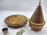 several pieces of brass are sitting on a white surface