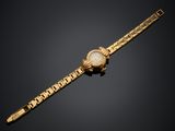 une montre en or avec un cadran blanc et un bracelet en or