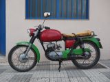 a red and green motorcycle parked in front of a building