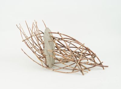 a sculpture of a bird made out of twigs on a white surface