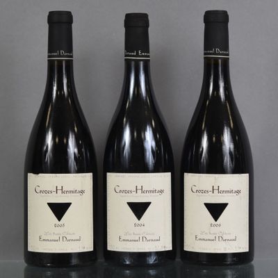 three bottles of red wine are lined up on a table