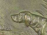 a bronze plaque of a dog on the side of a building