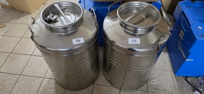 two stainless steel tanks sitting next to each other on the floor