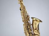 un saxophone doré sur fond noir et blanc
