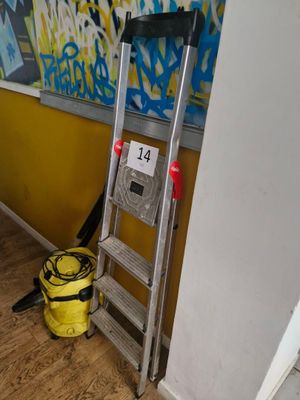 a ladder leaning against a wall with graffiti on the wall