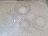 quatre plats en verre sur une table recouverte d'une nappe blanche