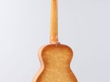 a close up of a guitar hanging from a string on a wall