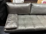 grey leather sofa with matching pillows and pillows on top of it