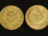 two pieces of gold coins on a black surface