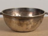 a silver bowl with handles on a table