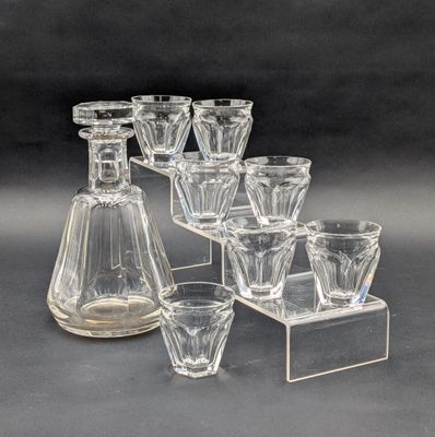 six verres et une carafe posés sur une table