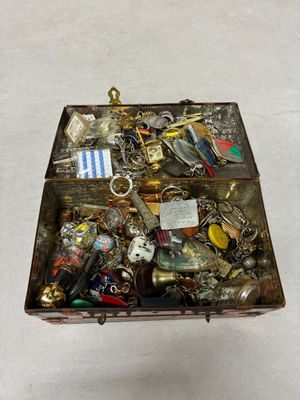une boîte métallique remplie d'objets divers posée sur une surface blanche