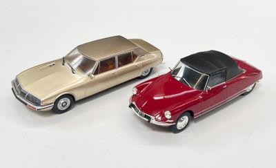 deux voitures jouets assises l'une à côté de l'autre sur une surface blanche