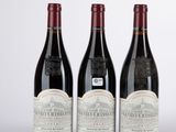 trois bouteilles de vin sont alignées sur une surface blanche