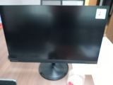 a computer monitor sitting on top of a wooden desk