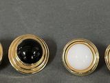 three pairs of black and white buttons on a gray surface