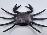 a metal sculpture of a crab on a white surface