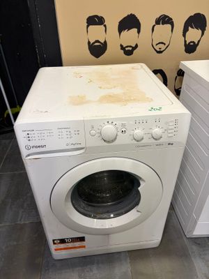 washing machine and dryer sitting on tiled floor in a room